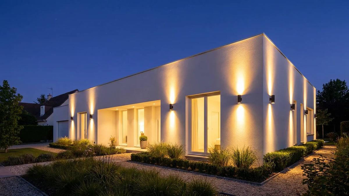 Façade de maison contemporaine éclairée la nuit par des appliques murales extérieures design
