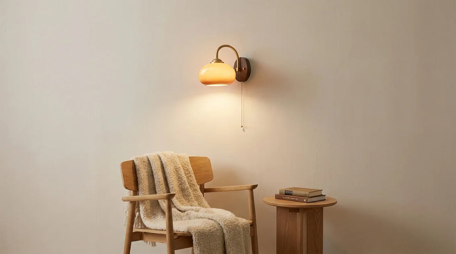 Applique murale en bois et verre allumée au-dessus d'un fauteuil de lecture en chêne
