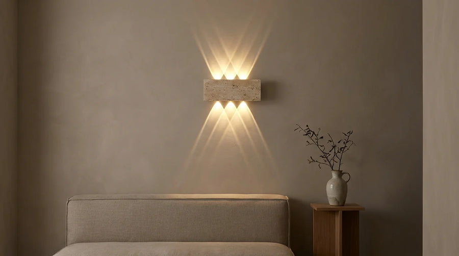 Applique murale LED en travertin projetant deux faisceaux de lumière sur le mur d'un salon