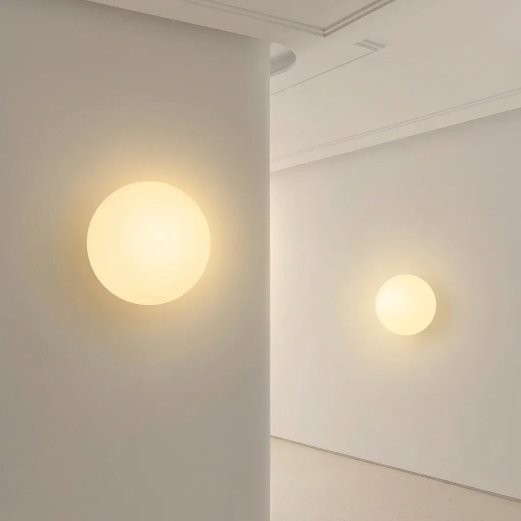 Grand et petit globes en verre opalin fixés au mur