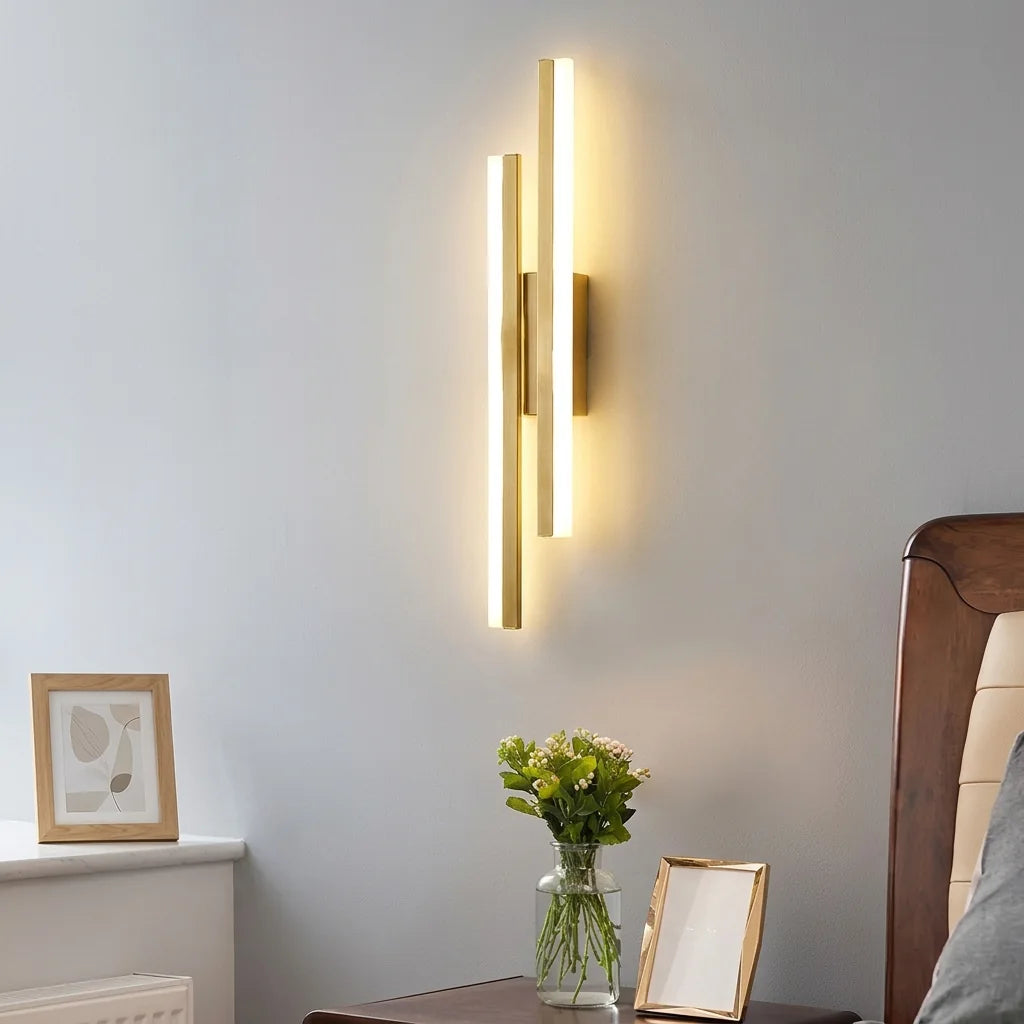 Applique LED dorée au-dessus d'une table de chevet fleurie