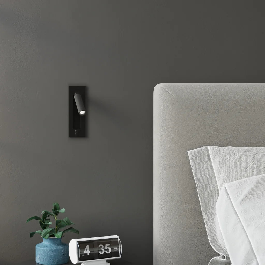 Applique liseuse noire encastrée à spot pivotant dans une chambre