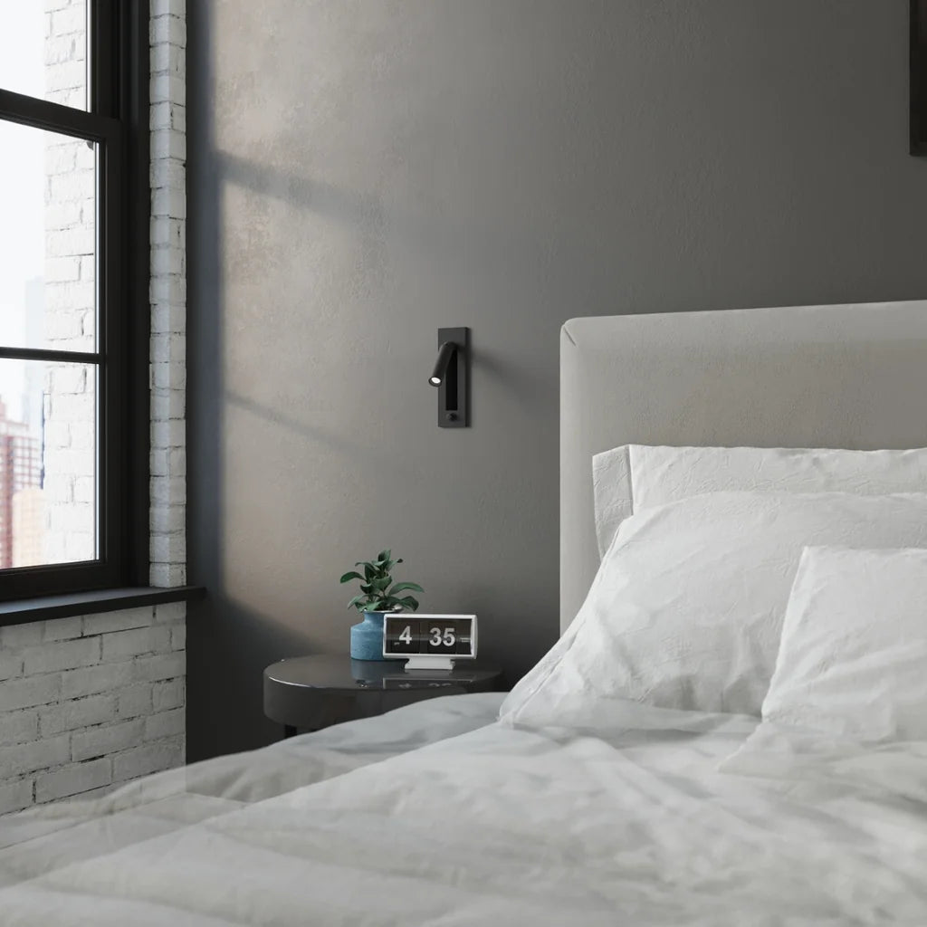 Applique liseuse noire encastrée à spot pivotant dans une chambre