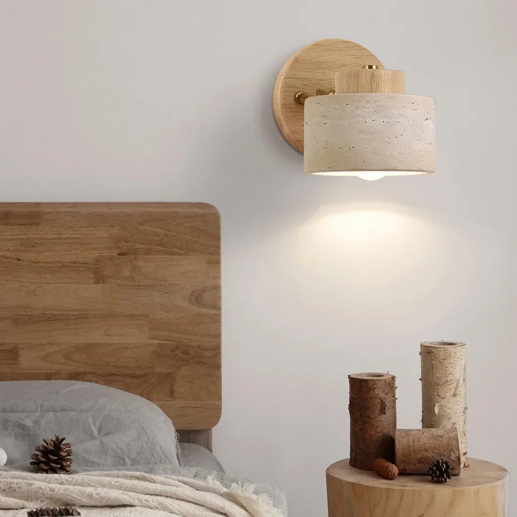 Applique liseuse en bois clair et travertin au-dessus d'une tête de lit en bois