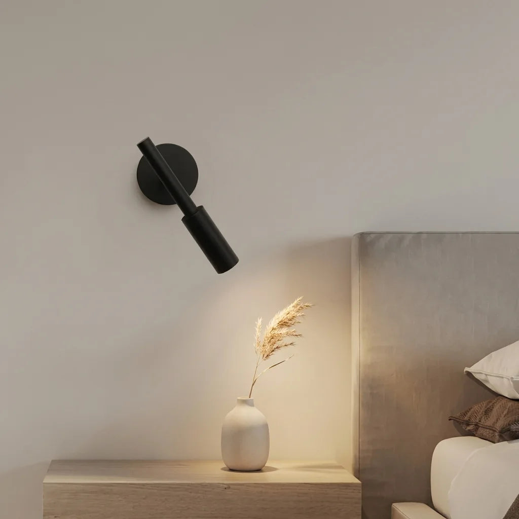 Applique liseuse noire au-dessus d'une table de chevet en bois clair