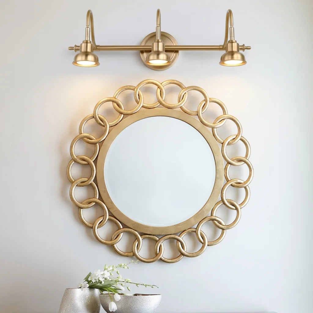 Applique bronze 3 têtes au-dessus d'un miroir rond à maillons dorés