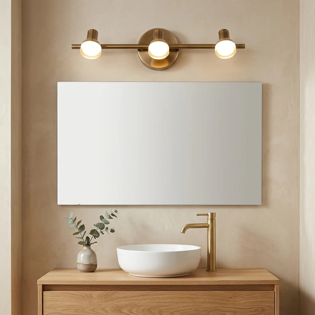 Applique LED bronze 3 spots au-dessus d'un miroir et d'une vasque en céramique