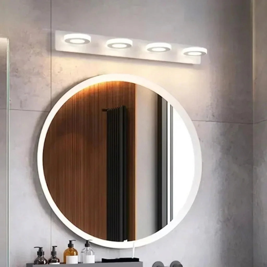 Applique 4 spots au-dessus d'un miroir rond rétroéclairé