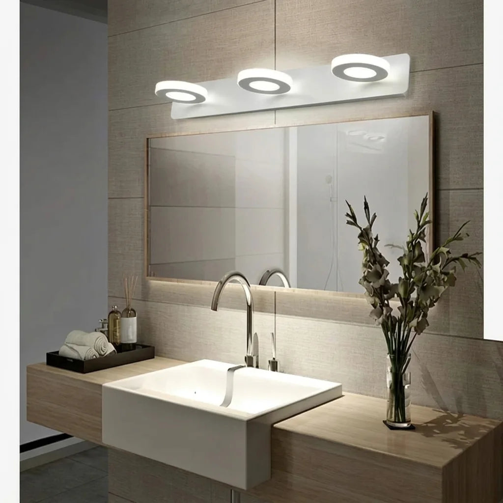 Applique 3 spots allumée au-dessus du miroir d'une salle de bain