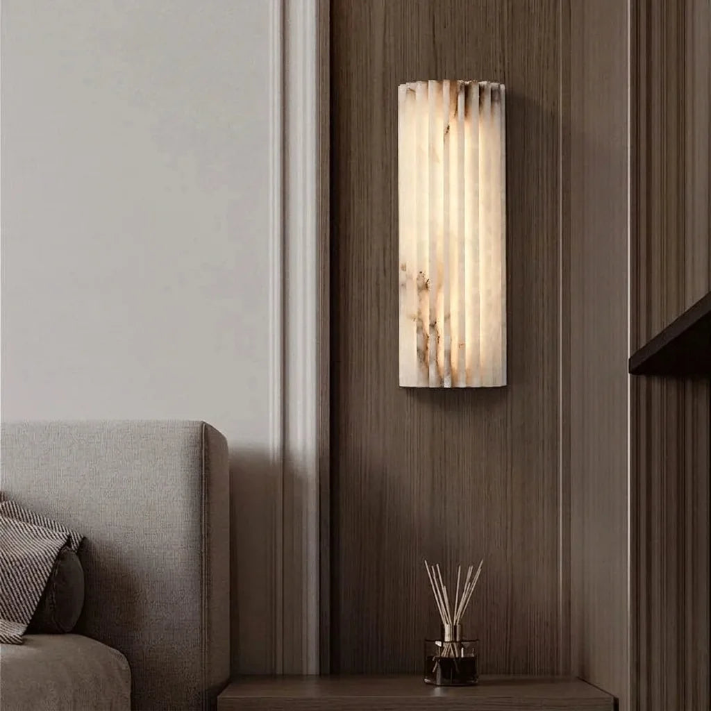 Applique en albâtre sur un panneau en bois près d'un lit gris