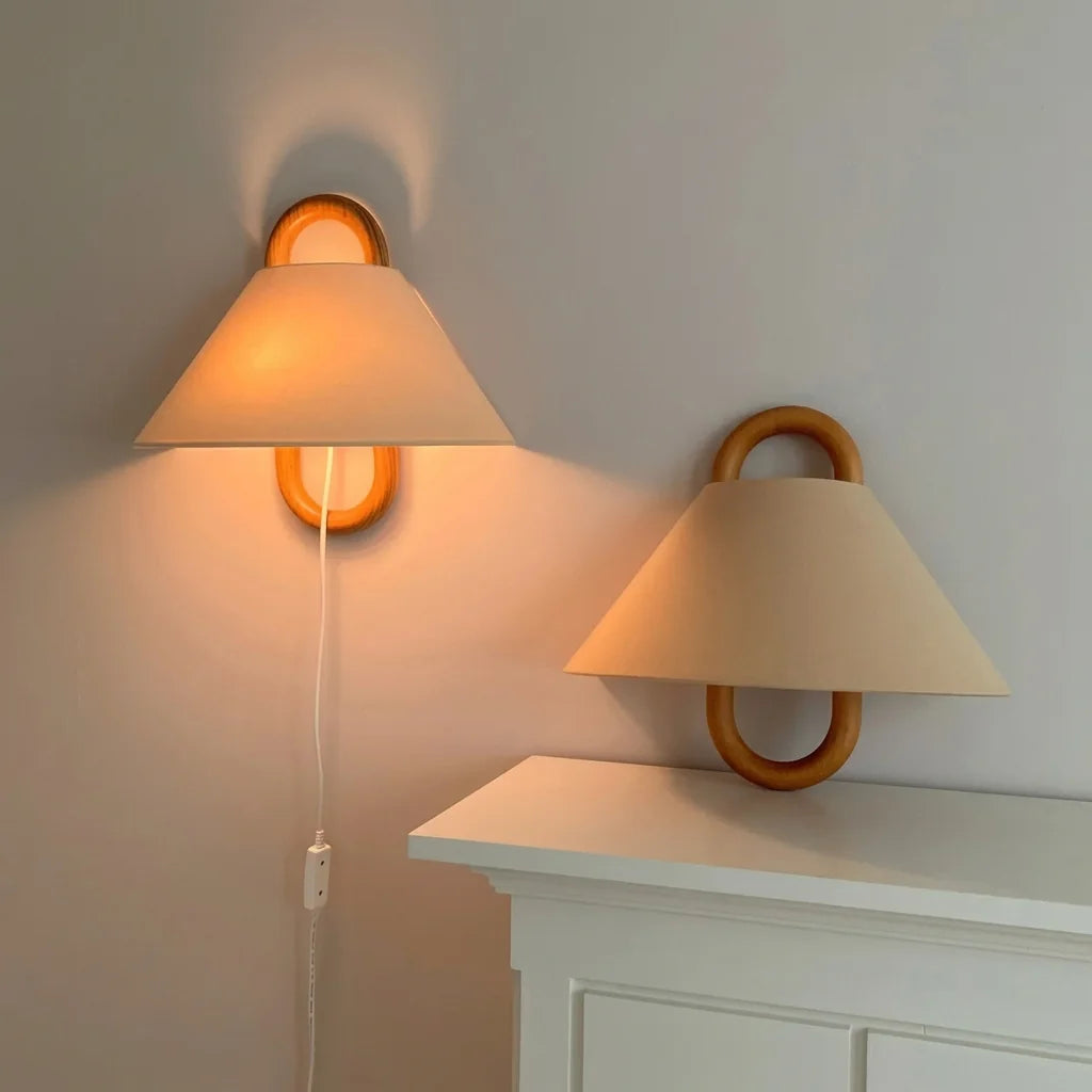 Deux appliques anneau en hêtre au-dessus d'une commode blanche