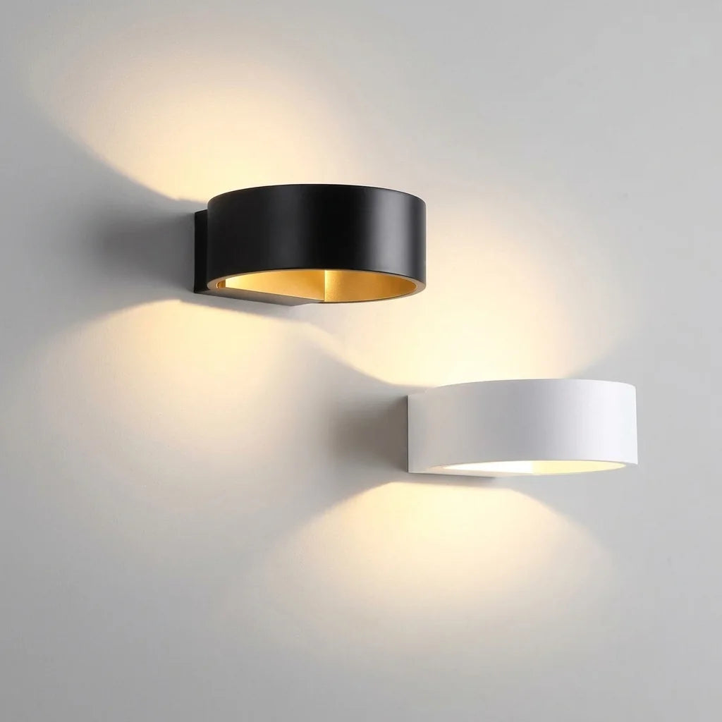 Appliques anneau LED noire et blanche projetant leurs faisceaux sur un mur gris