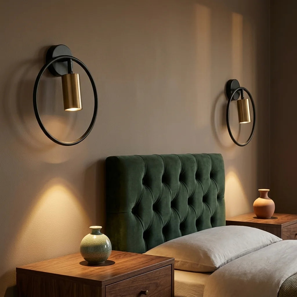 Deux appliques anneau noir et spot bronze autour d'une tête de lit verte