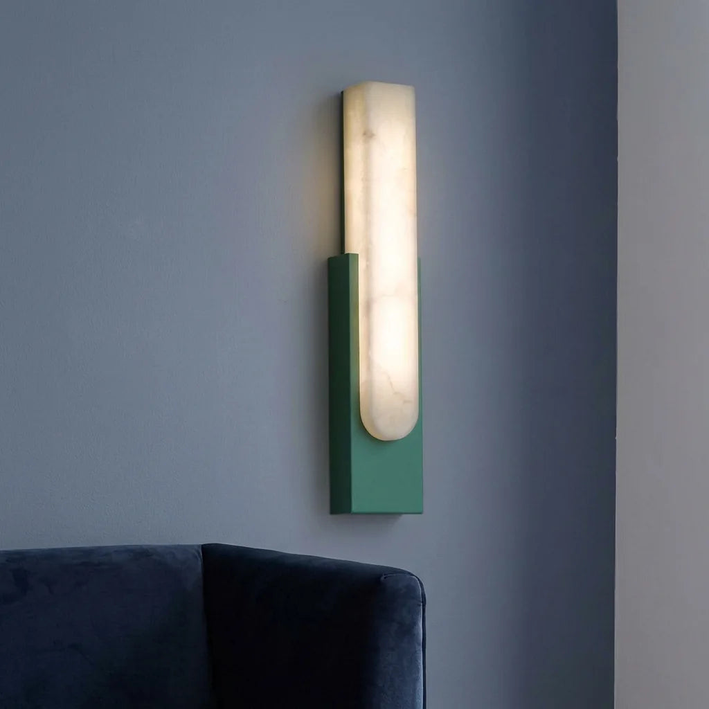 Applique en marbre sur base verte au-dessus d'un canapé en velours bleu
