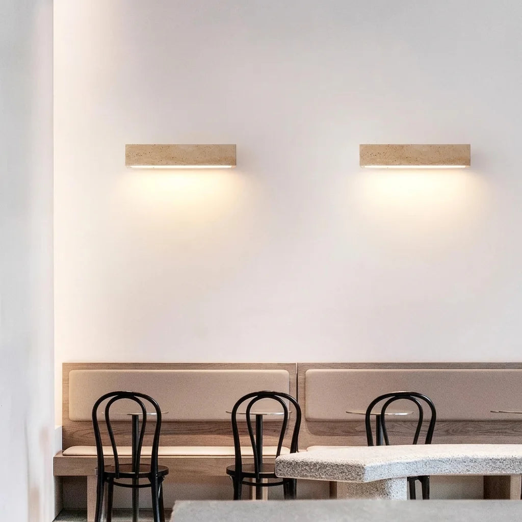 Deux appliques en travertin au-dessus d'une banquette de café