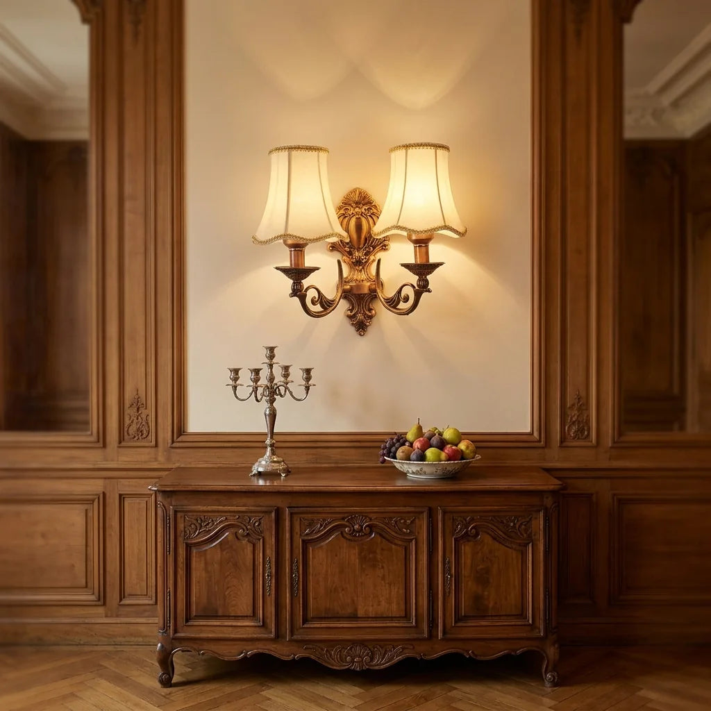 Applique bougeoir double tête allumée au-dessus d'un buffet ancien