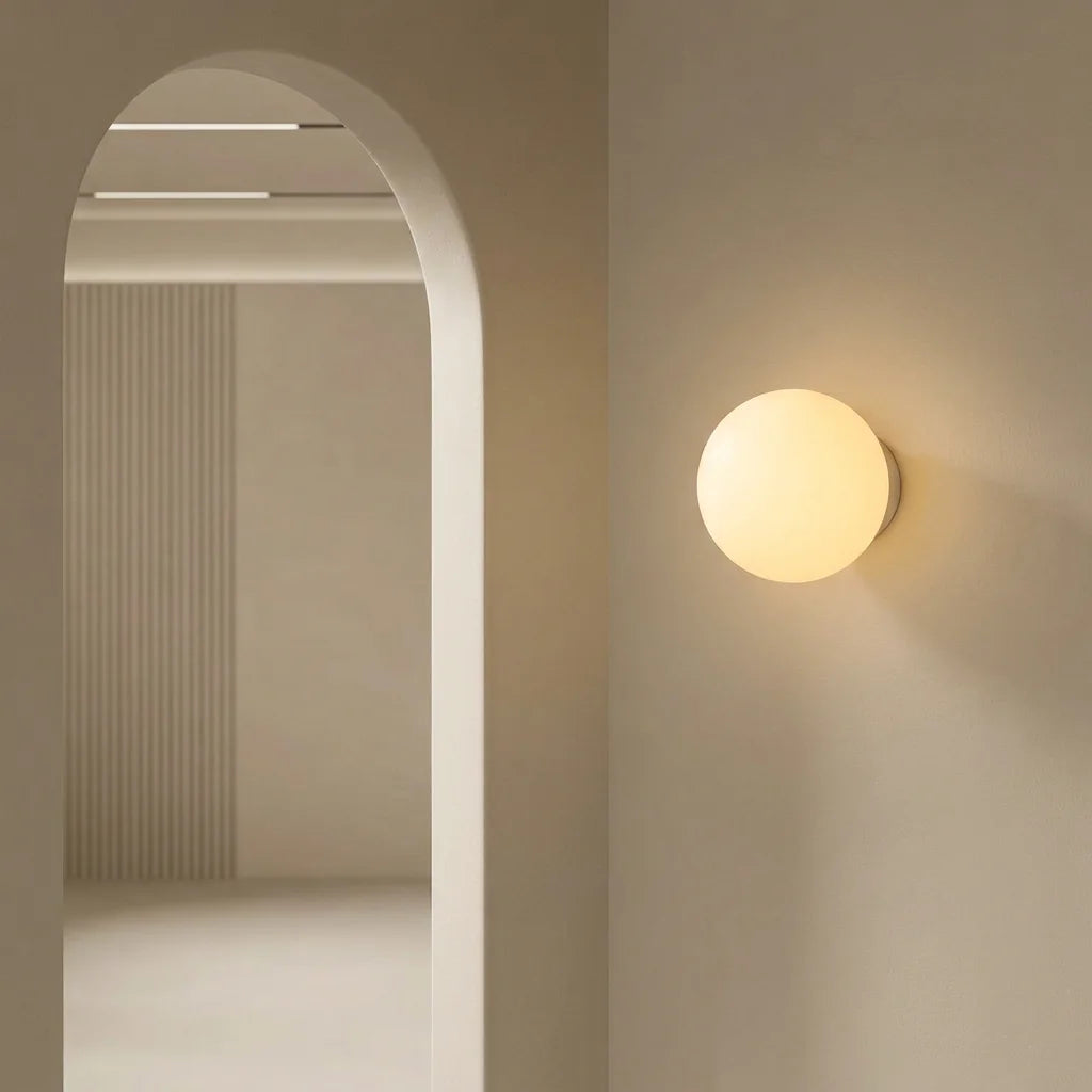 Applique boule opaline près d'une arche dans un couloir