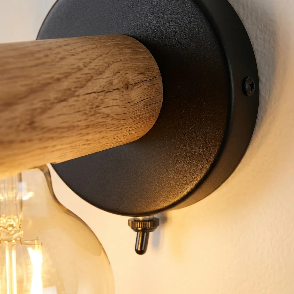 Bras en chêne, platine noire et interrupteur de l'applique vus de près