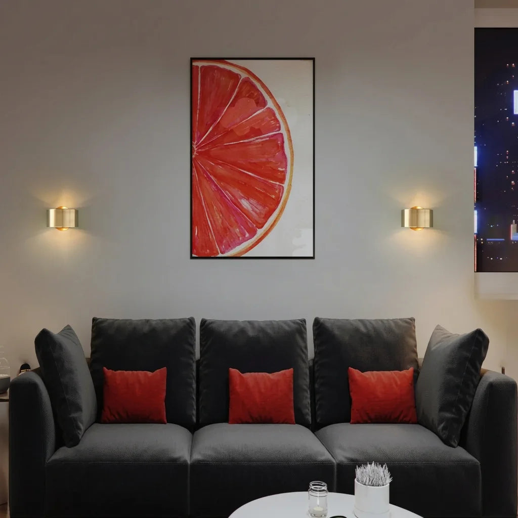 Appliques cylindre dorées de part et d'autre d'une affiche au-dessus d'un canapé