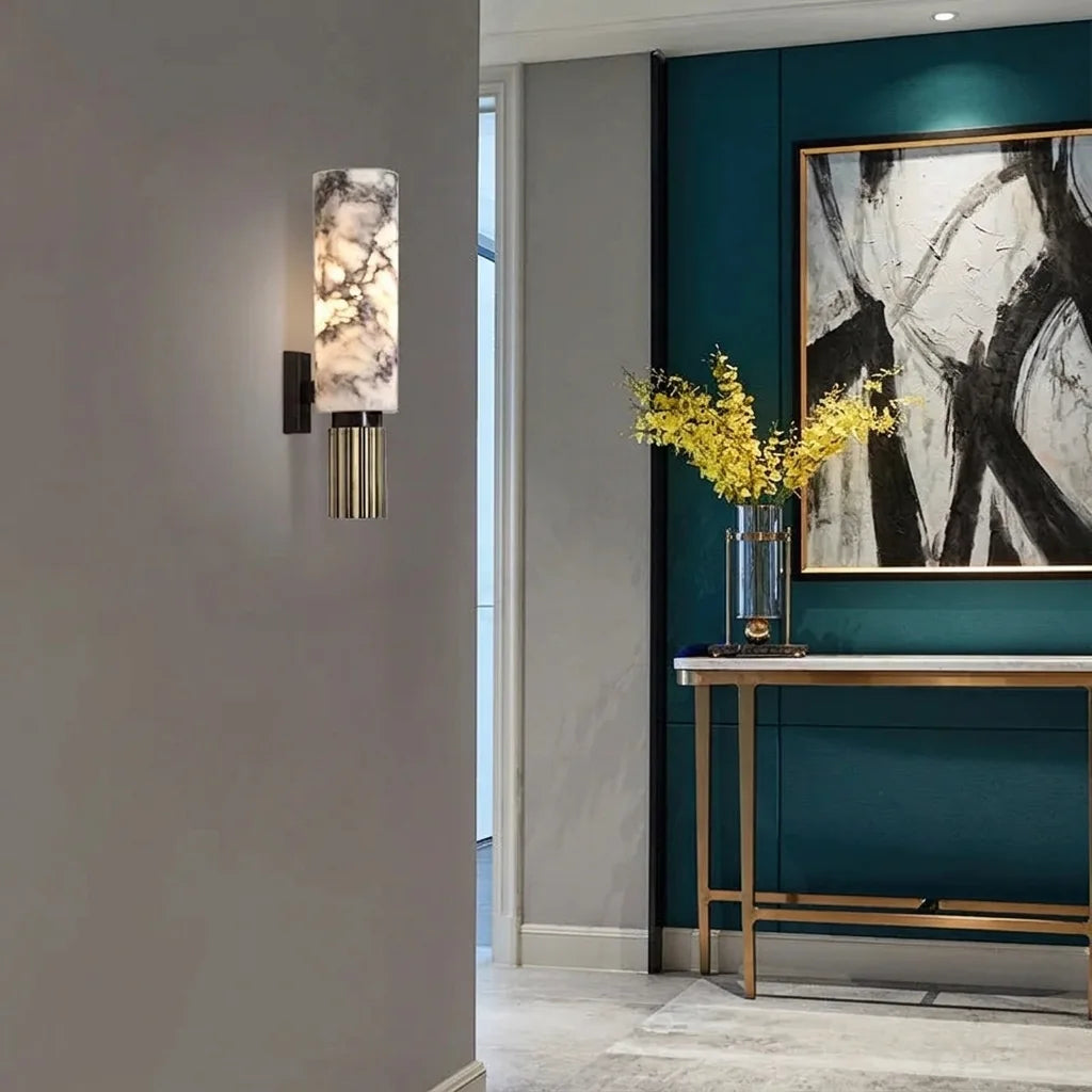 Applique cylindre en marbre dans une entrée avec console dorée