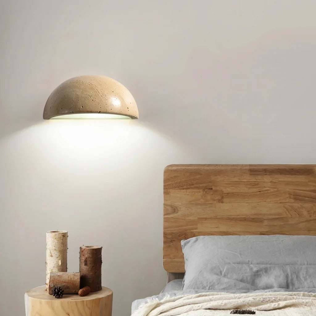 Applique demi-coupe en travertin au-dessus d'un lit en bois
