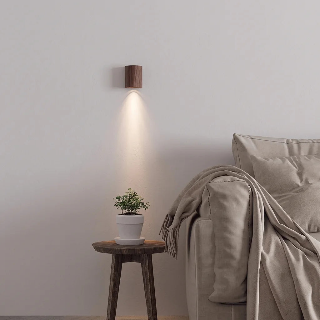 Petite applique en noyer éclairant un mur gris au-dessus d'un tabouret