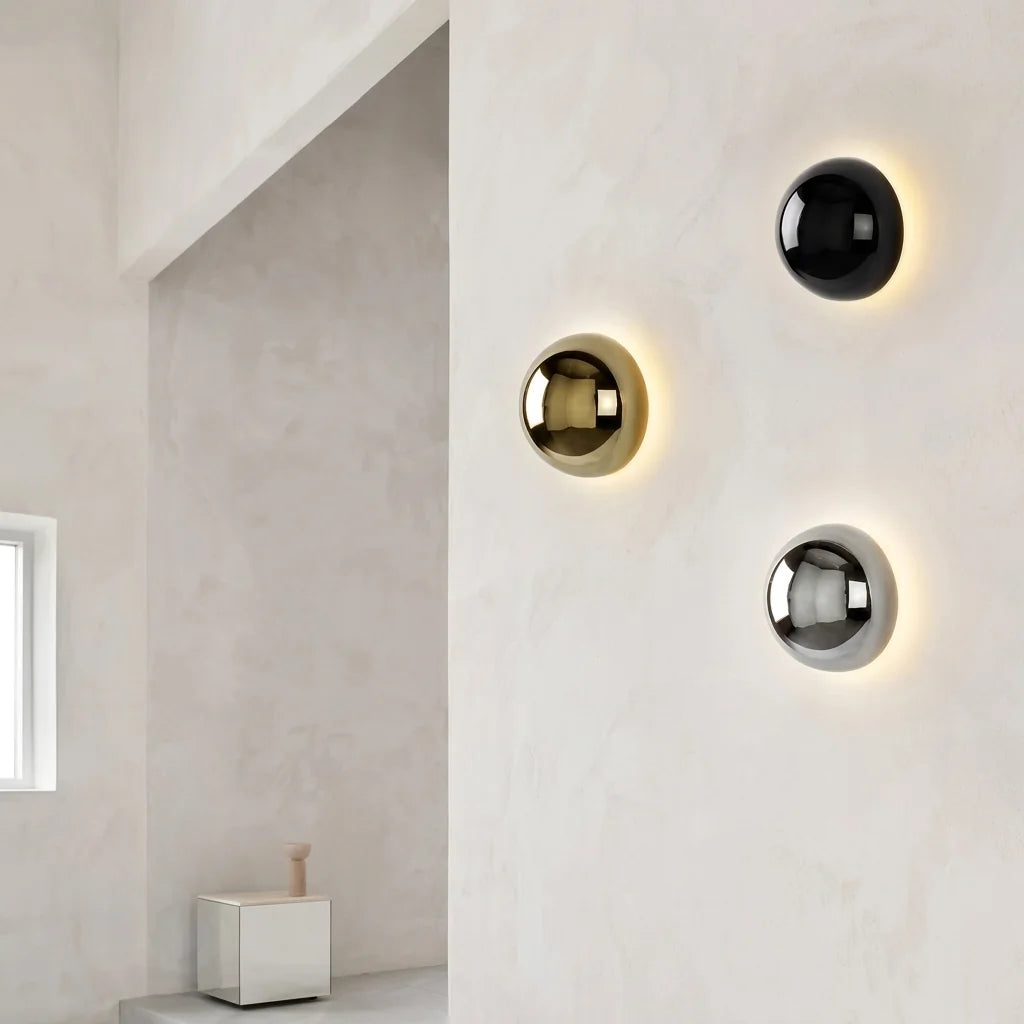 Composition de trois appliques demi-sphère sur un mur enduit blanc