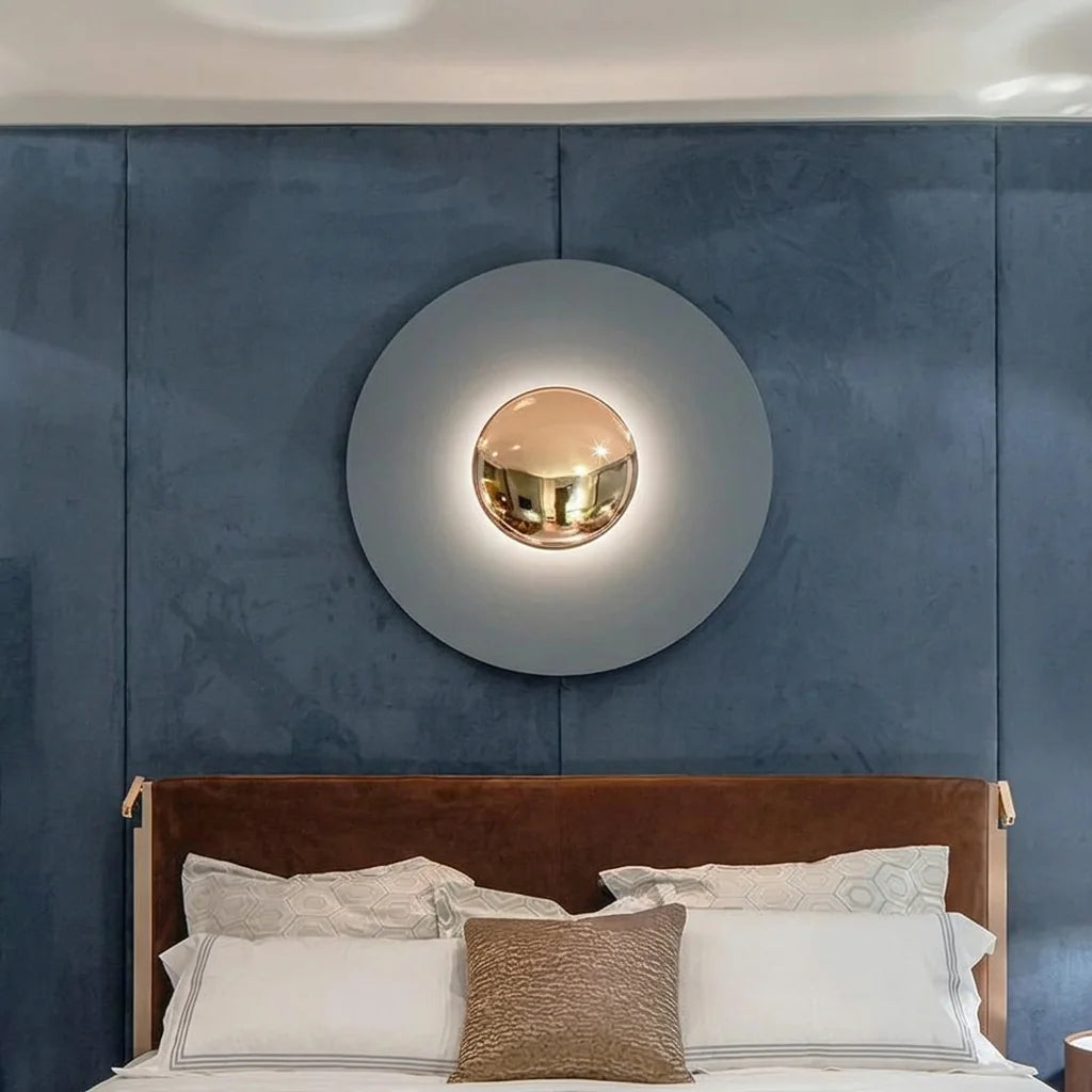 Grande applique disque à dôme doré au-dessus d'un lit, mur en velours bleu