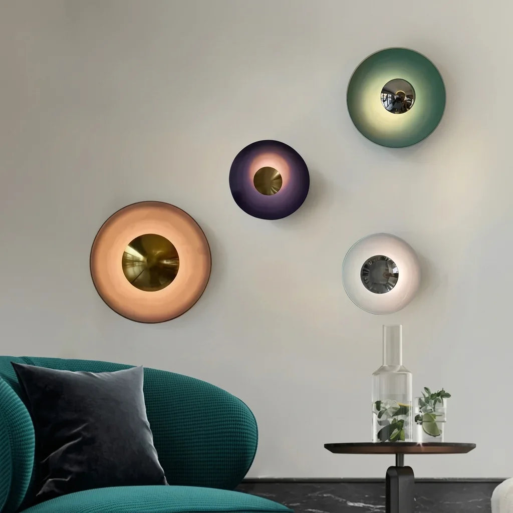 Composition de quatre appliques disque colorées au-dessus d'un fauteuil vert