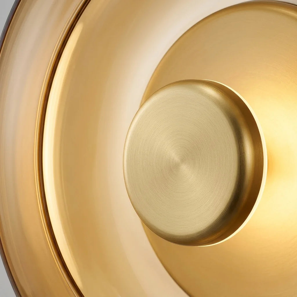 Disque en laiton brossé et bord en verre ambre de l'applique vus de près