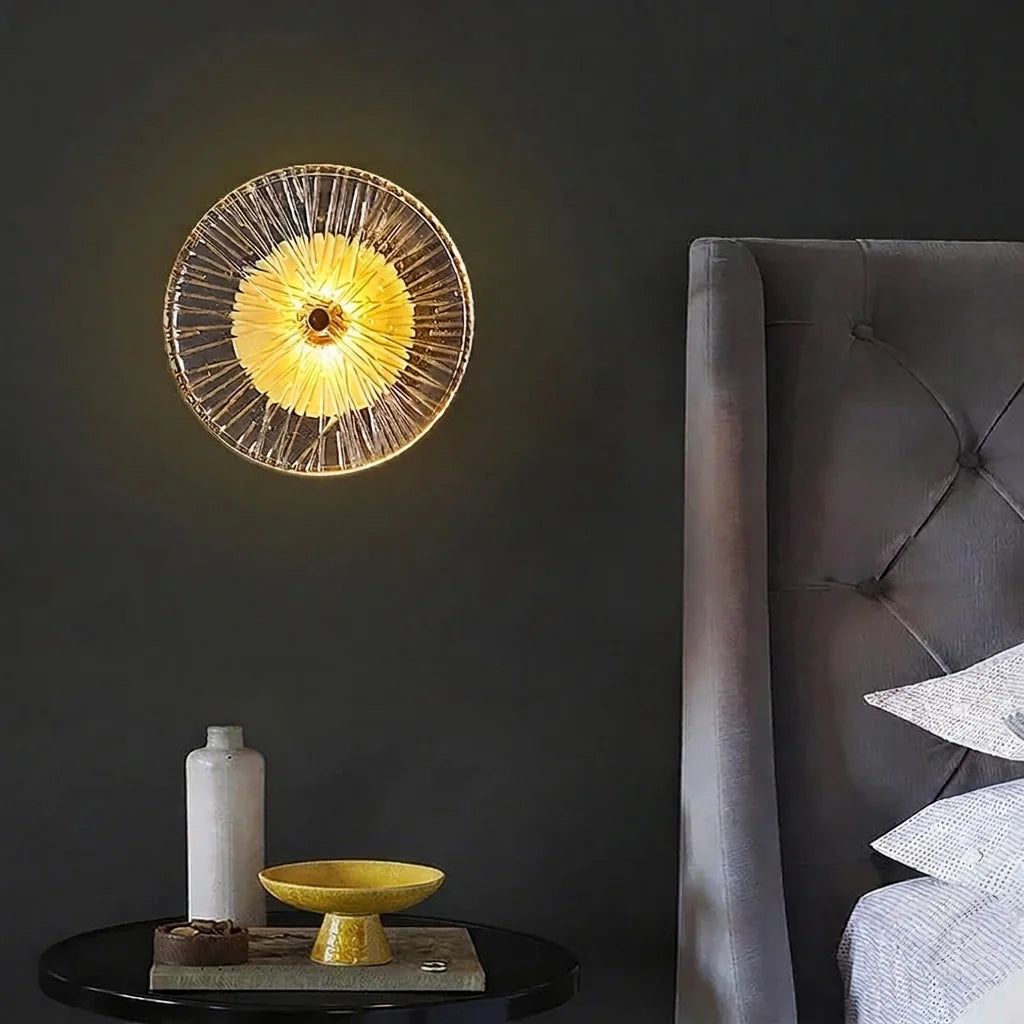 Applique ronde en verre au-dessus d'une table de chevet, mur sombre