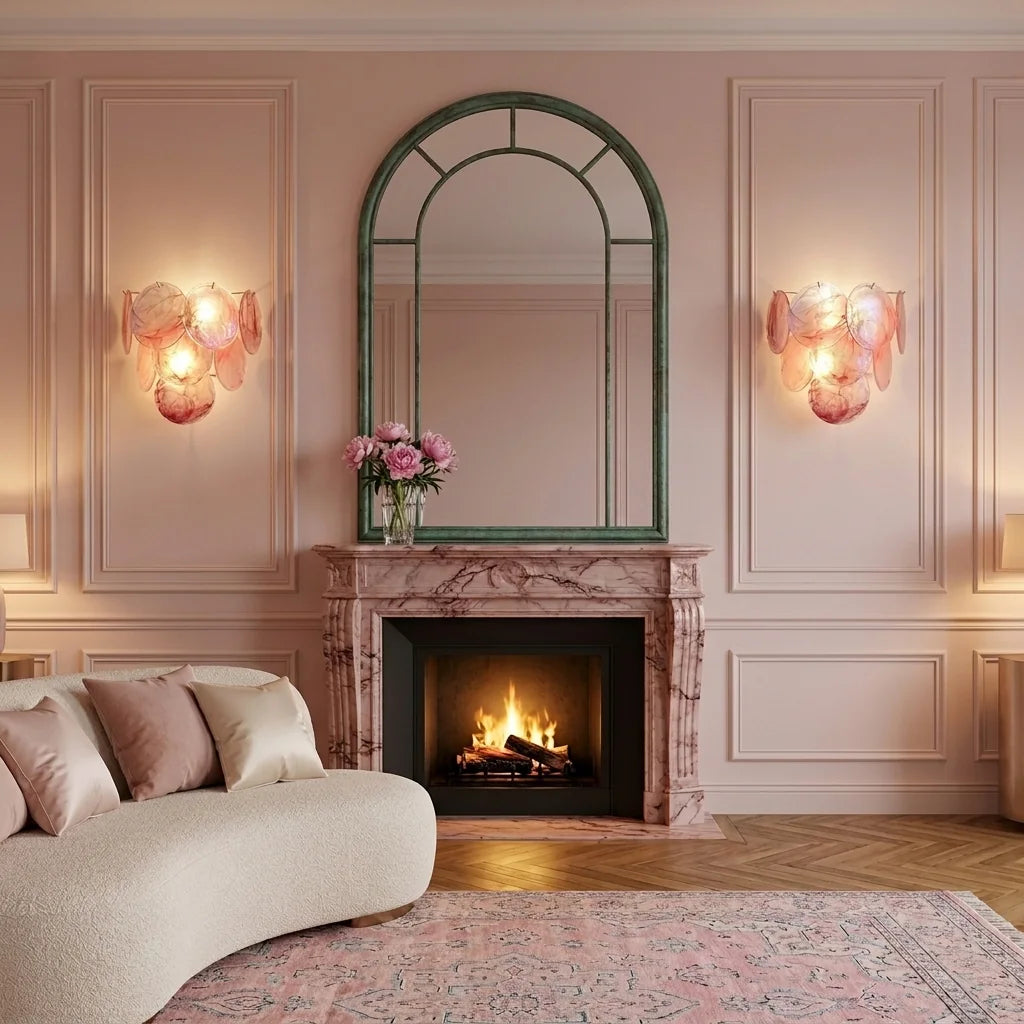 Deux appliques en disques de verre rose encadrant un miroir au-dessus d'une cheminée