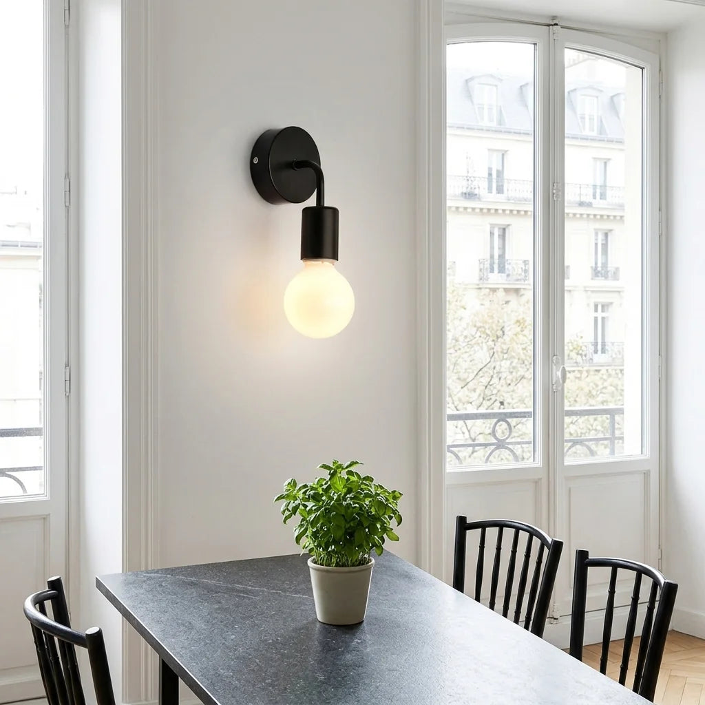 Applique noire minimaliste près d'une fenêtre parisienne, coin repas