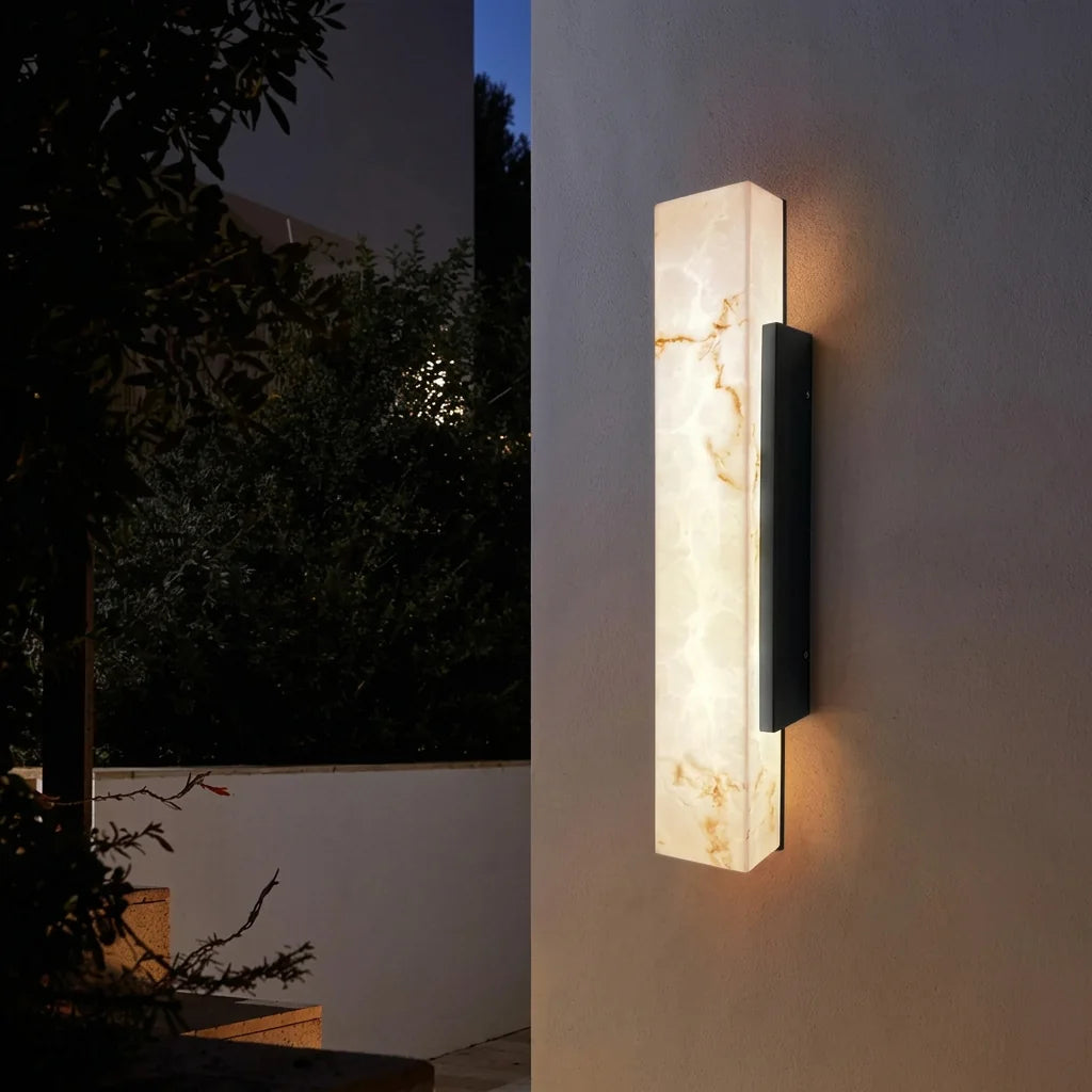 Applique colonne effet marbre sur un mur extérieur, jardin la nuit