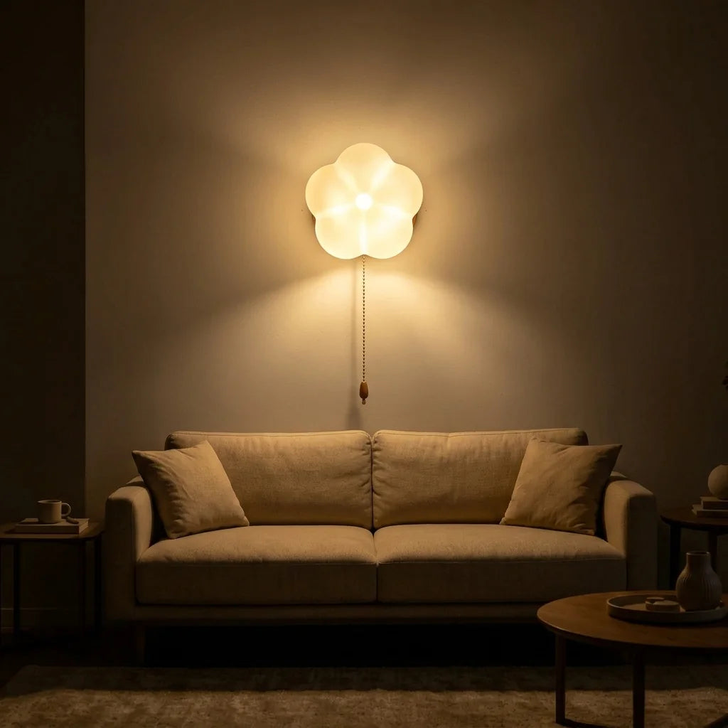 Applique fleur opaline allumée au-dessus d'un canapé beige le soir