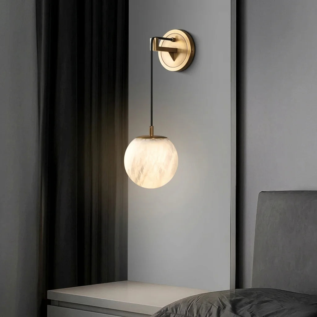 Applique globe en albâtre et cuivre doré près d'un rideau, chambre