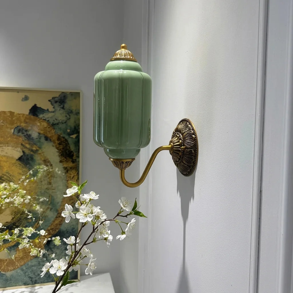 Applique lanterne verte et laiton à côté d'un tableau abstrait doré
