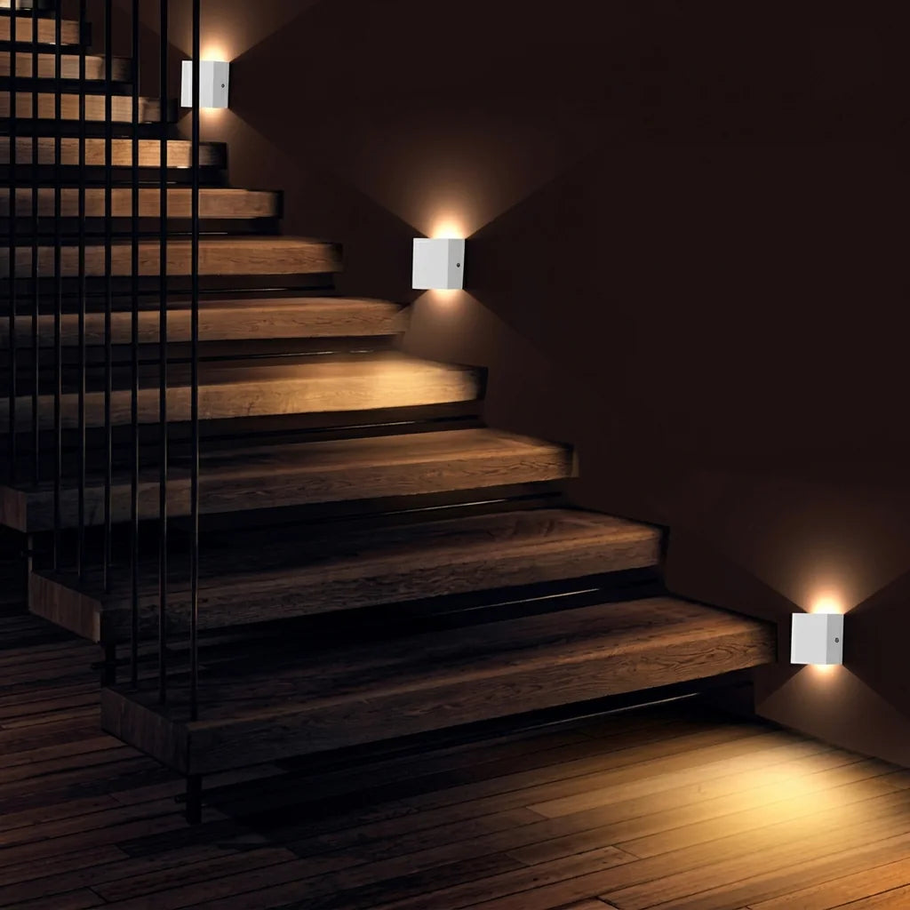 Appliques cube blanches éclairant un escalier en bois