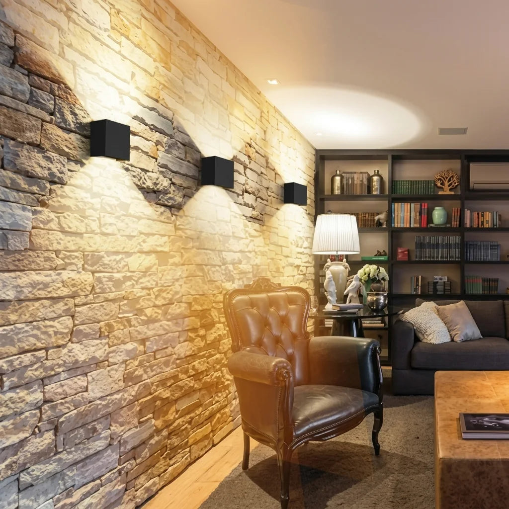Trois appliques cube noires sur un mur en pierre de salon
