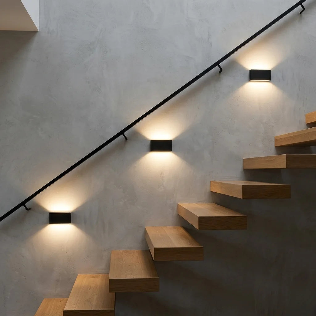 Trois appliques LED noires le long d'un escalier suspendu en chêne