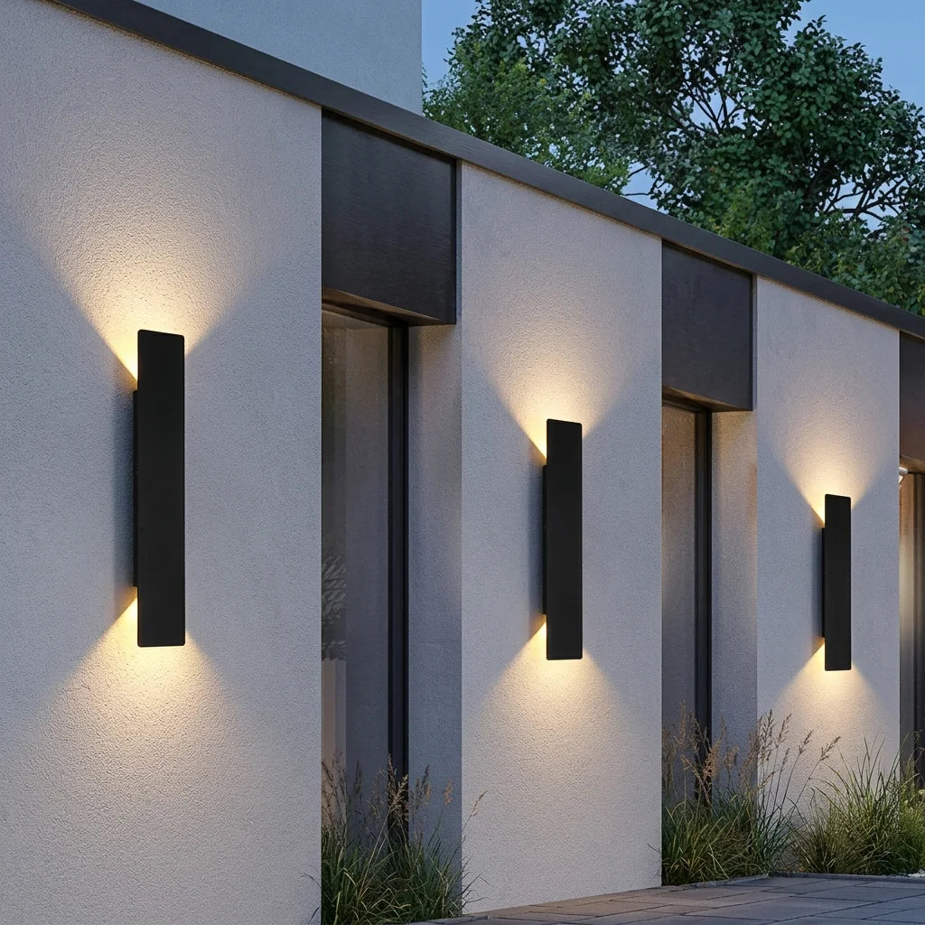 Trois appliques LED étanches sur un mur de clôture contemporain