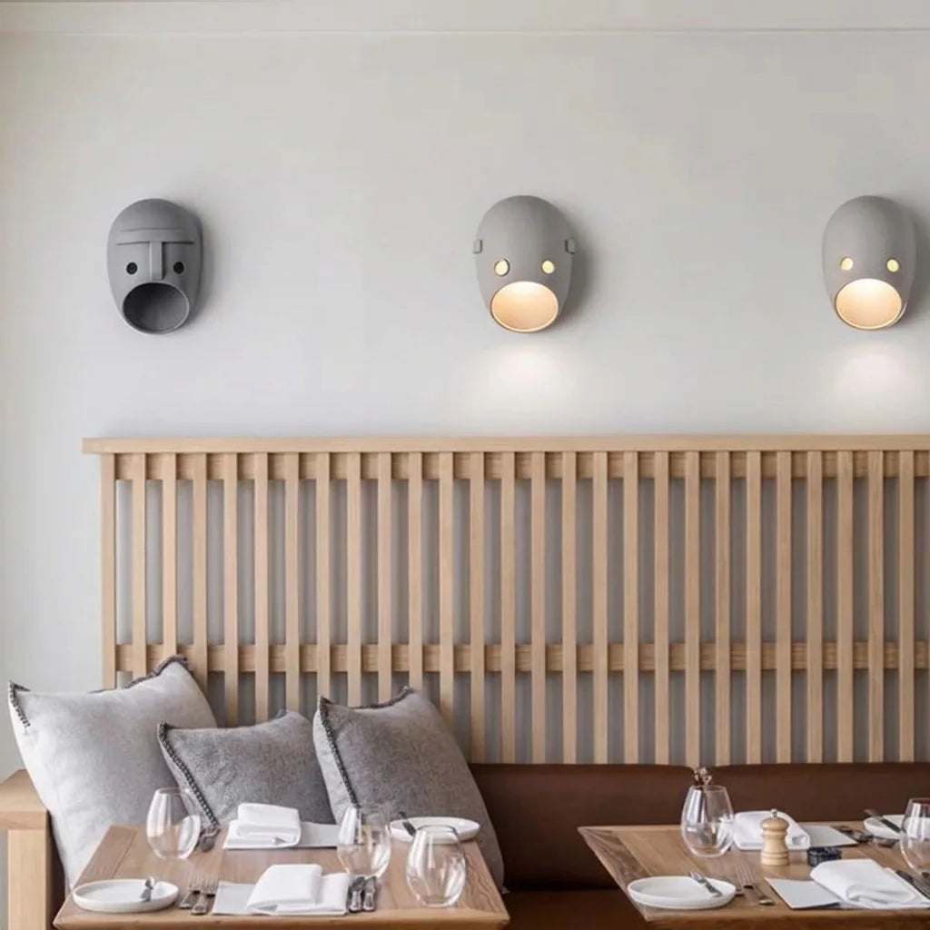 Trois appliques masque au-dessus d'une banquette de restaurant