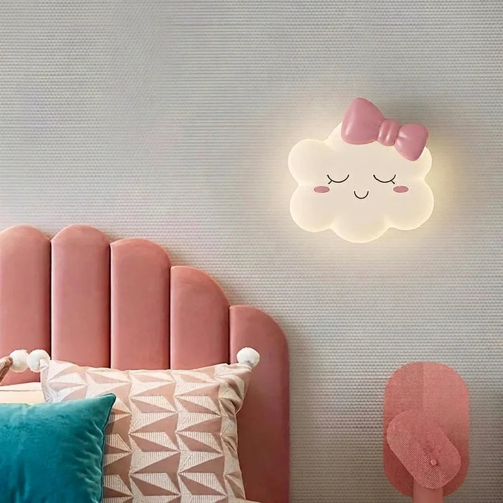 Applique nuage à nœud rose au-dessus d'une tête de lit en velours rose