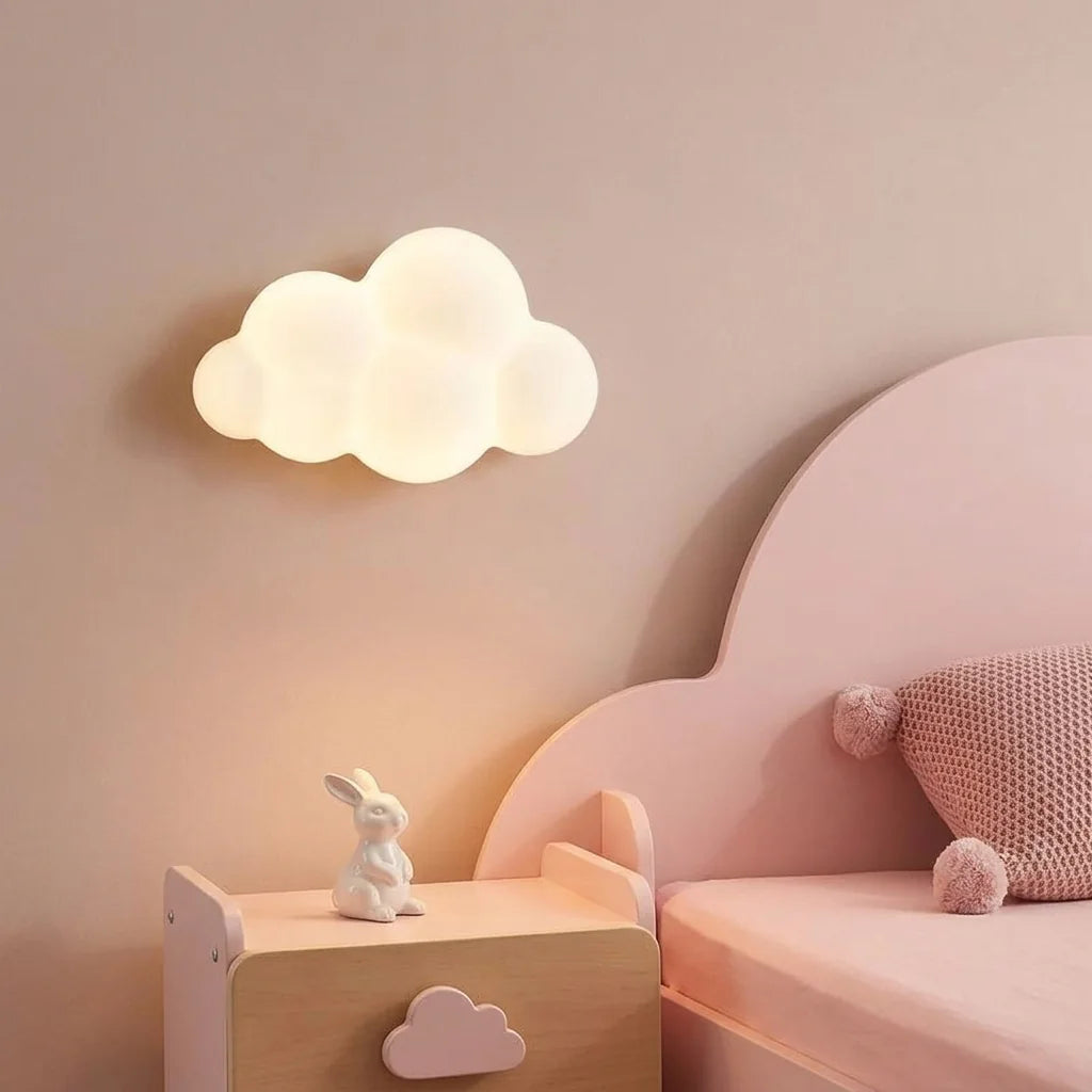 Applique nuage allumée dans une chambre d'enfant rose