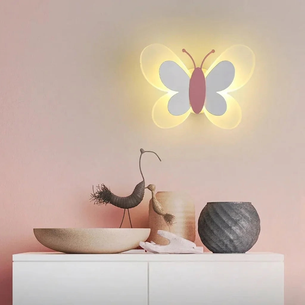 Applique papillon allumée sur un mur rose au-dessus d'un buffet blanc