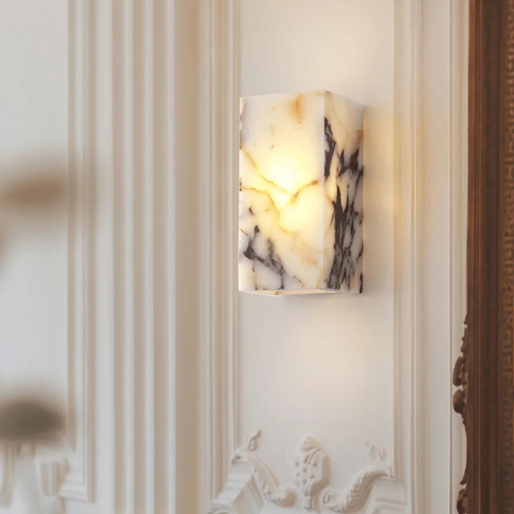 Applique en pierre veinée sur un mur blanc à moulures classiques