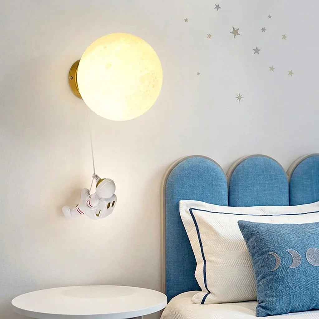 Applique lune et astronaute près d'une tête de lit bleue