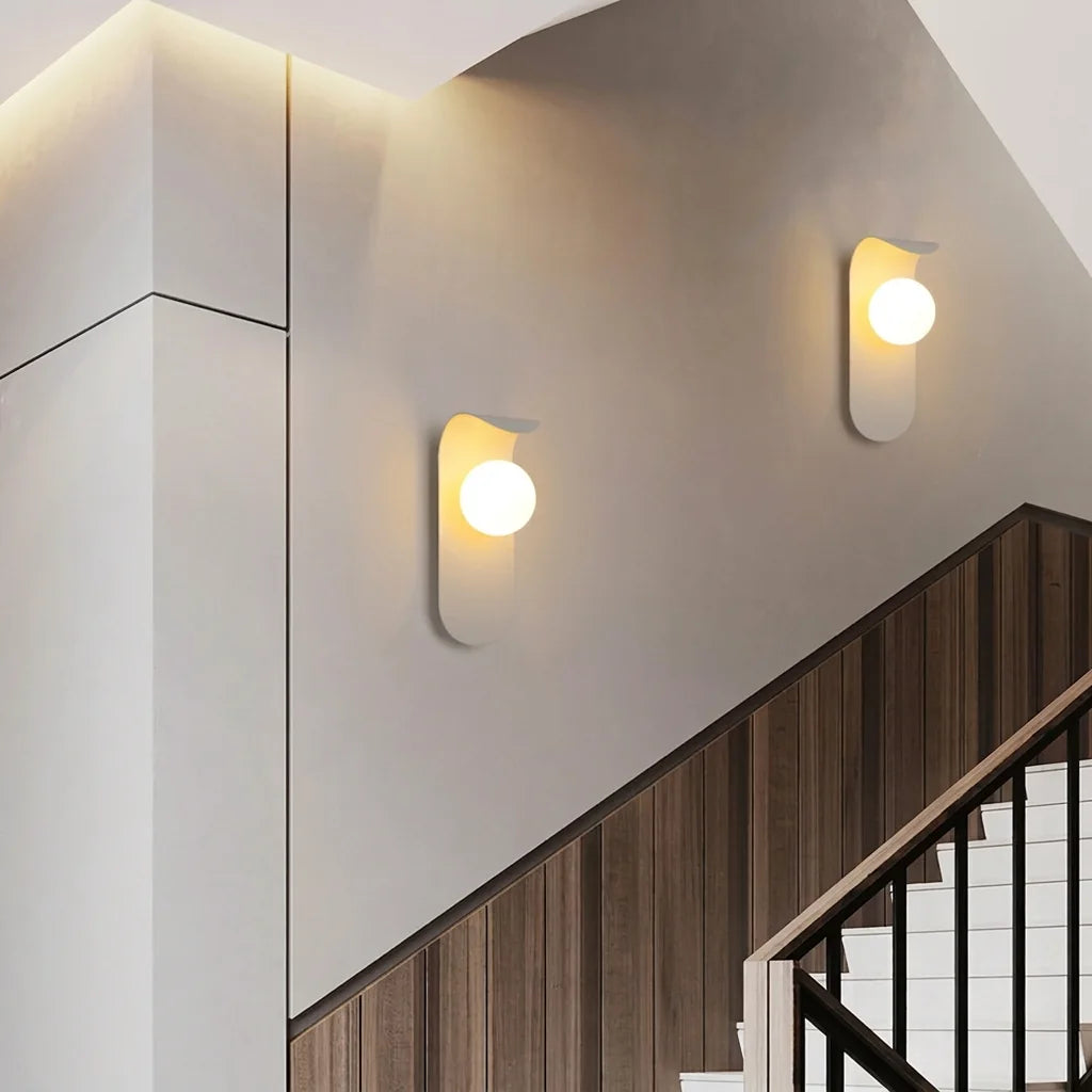 Deux appliques LED blanches à globe le long d'un escalier en bois