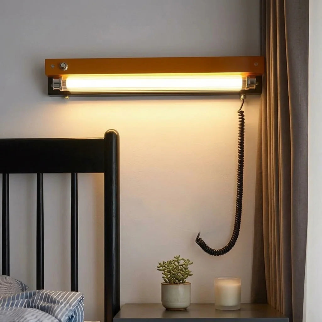 Réglette rétro orange au-dessus d'une table de chevet près d'un lit noir