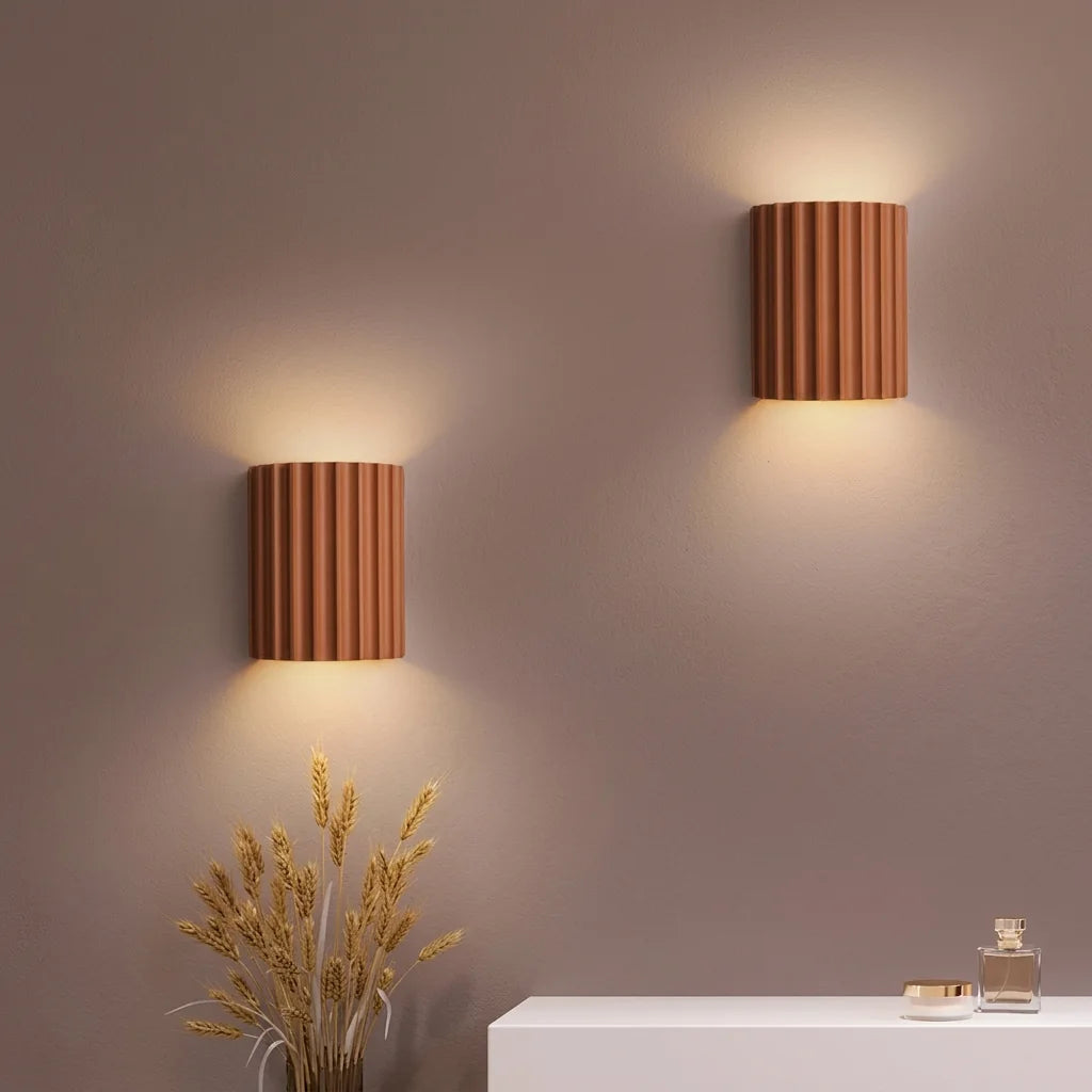 Deux appliques plissées terracotta sur un mur taupe